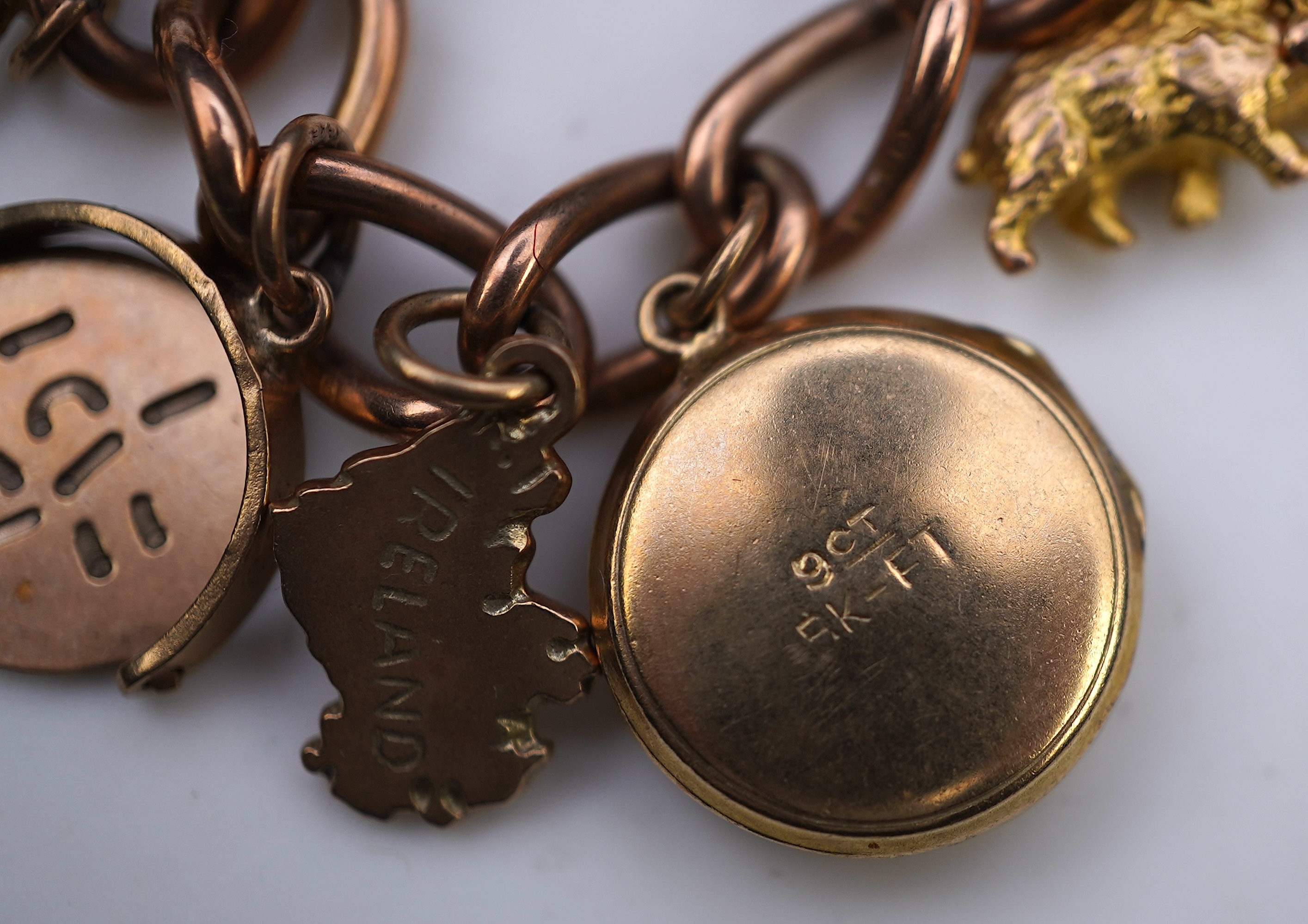 A gold charm bracelet, mid 20th century